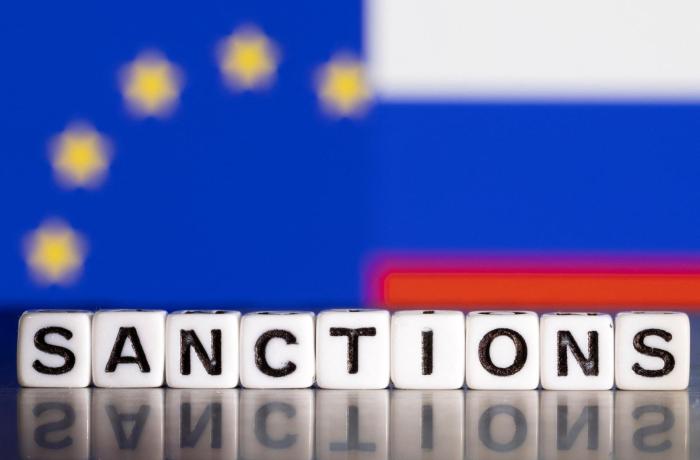 letterstenen sanctions met op achtergrond Europese en Russische vlag